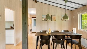 A dining area with a wooden table and chairs, pendant lights, and framed pictures on the wall. - "Julika" - 560m from the sea by Interhome (Sæby)