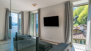 Un salon moderne doté d’une grande fenêtre, d’un téléviseur à écran plat et d’une cloison en verre.