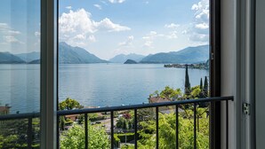 Un lac avec des montagnes en arrière-plan, vu depuis un balcon doté d’une balustrade.