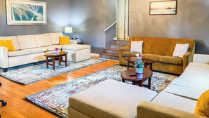 Una sala de estar con sofá, sillón, mesa de centro y candelabro.