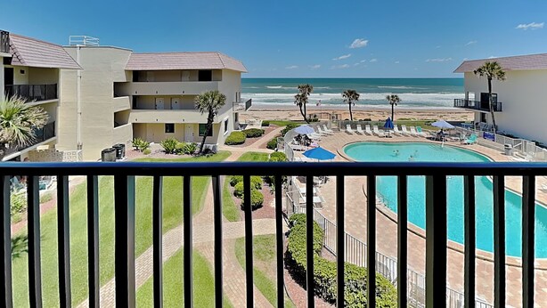 Resort com piscina, vista para a praia e edifícios de vários andares.