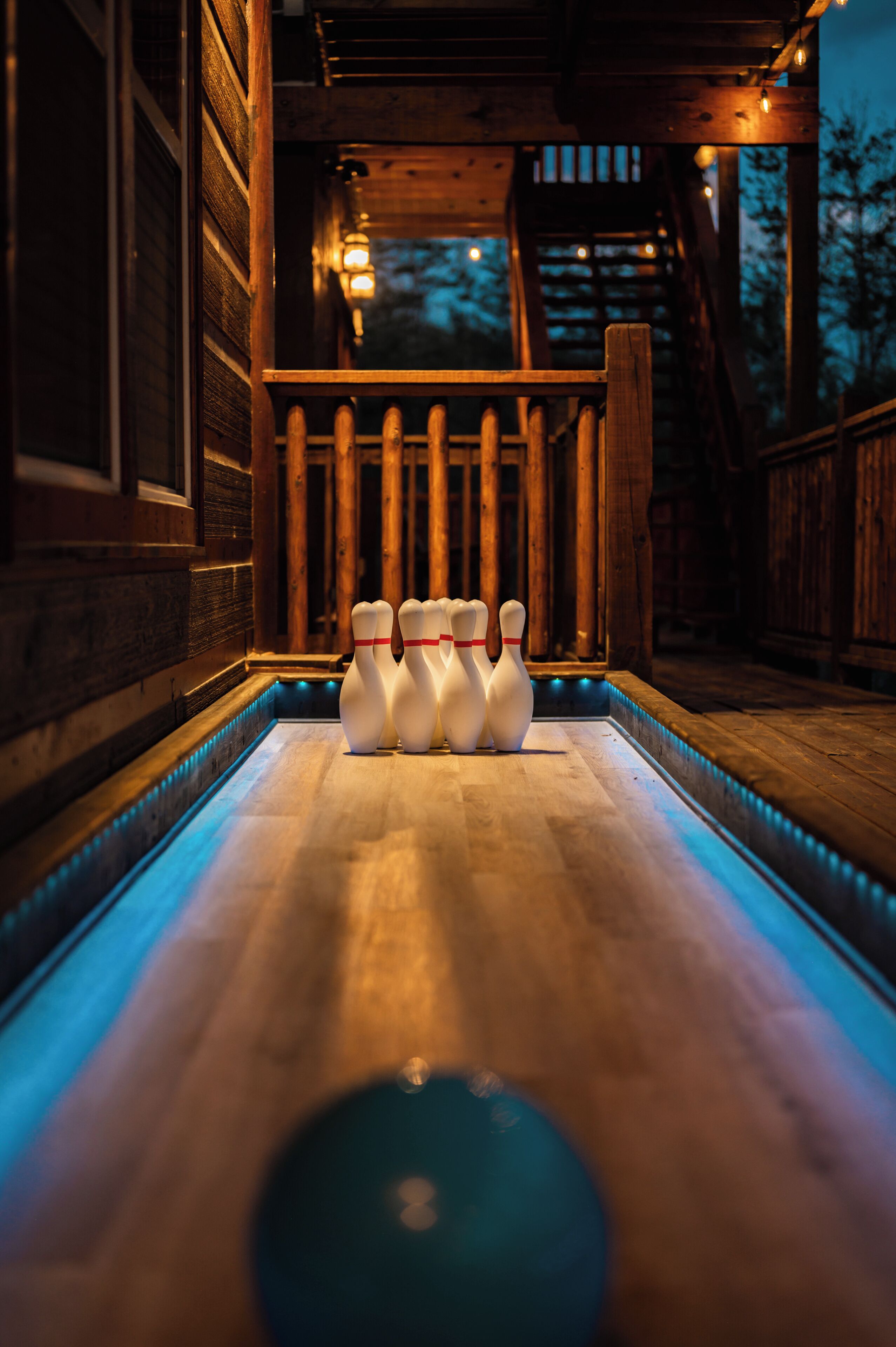 A bowling alley with wooden surroundings and a well-lit lane.