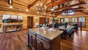 A spacious kitchen with a large island, wooden beams, and a chandelier. - Bethlehem Lodge (Sevierville)