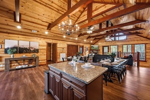 A spacious kitchen with a large island, wooden beams, and a chandelier. - Bethlehem Lodge (Sevierville)