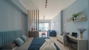 Una camera da letto moderna con un letto, una scrivania e vista sul mare.