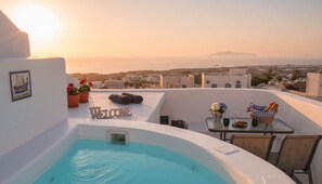 Eine Dachterrasse mit Swimmingpool, einem Willkommensschild, einem Tisch mit einem Brotkorb und Blick auf Stadt und Berge in der Ferne.