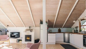A modern interior with a fireplace, kitchen, and seating area. - 4 Person Holiday Home in Gilleleje (Gilleleje)