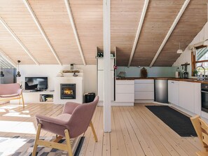 Ein modernes Interieur mit Kamin, Küche und einer Sitzecke.