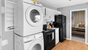 A compact kitchen with a washing machine, a refrigerator, and a stove.