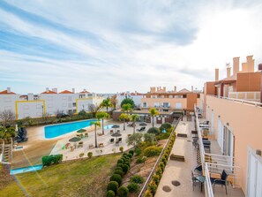A residential building with a swimming pool, outdoor seating, and a garden area.