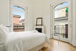 A bedroom with a bed, a fireplace, and a view of the outside. - 1905 Corner Flat · Temporary Stay · Las Letras (Madrid)