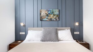 Una camera da letto con un letto, due comodini, una lampada a parete e un quadro.