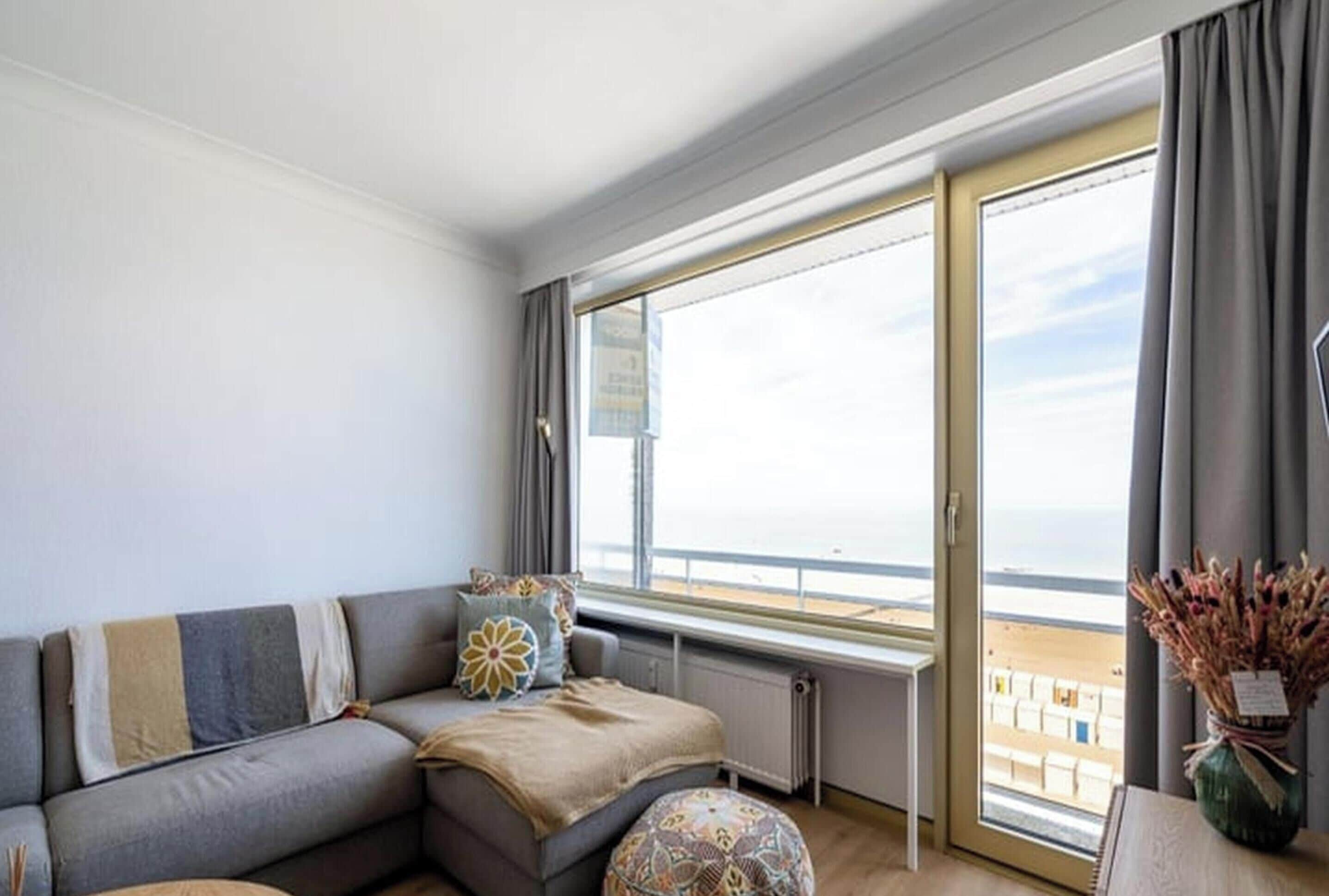 A living room with a sofa, a window with a view, and a radiator.