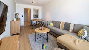 Una sala de estar moderna con un sofá, una mesa de centro y un televisor.