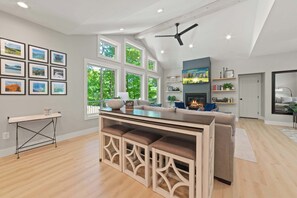 Eine moderne Küche mit einer zentralen Kochinsel, großen Fenstern und einem Deckenventilator.