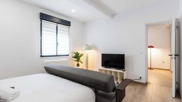 Laptop workspace, iron/ironing board, bed sheets