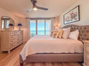 A bedroom with a large bed, a ceiling fan, a dresser, and a balcony with a view. - Stunning 3BR/3BA Brighton Tower | Fully Renovated (Myrtle Beach)