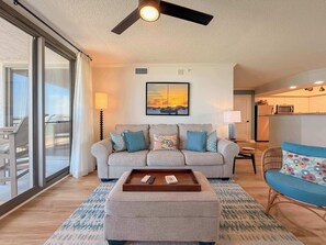 A living room with a sofa, ottoman, and a ceiling fan. - Stunning 3BR/3BA Brighton Tower | Fully Renovated (Myrtle Beach)
