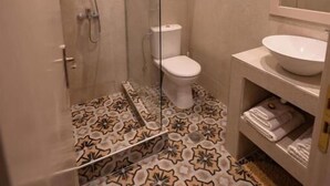 A bathroom with a shower, toilet, and sink.