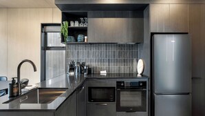 Una cocina moderna con horno empotrado, refrigerador y pileta.