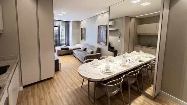 Un interior moderno con zona de comedor, sofá y cocina.