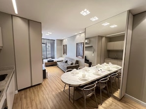 A modern interior with a dining area, sofa, and kitchen. - LK Santo Agostinho 7 (Belo Horizonte)