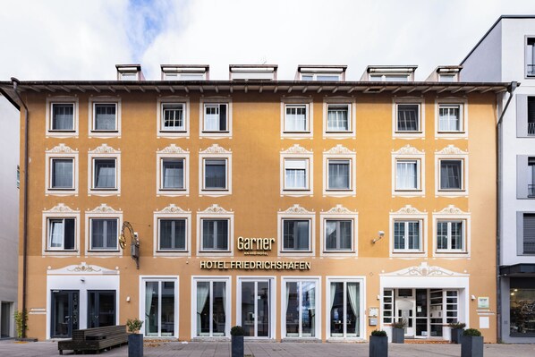 A hotel facade with multiple windows, a central entrance, and a sign reading 'Garner Hotel Friedrichshafen.' - Garner Hotel Friedrichshafen By IHG (Friedrichshafen)