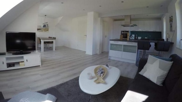 En moderne lejlighed med stue, spiseområde og køkken.