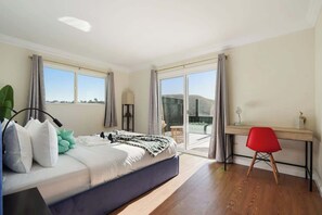 Een slaapkamer met een bed, een bureau en een stoel.
