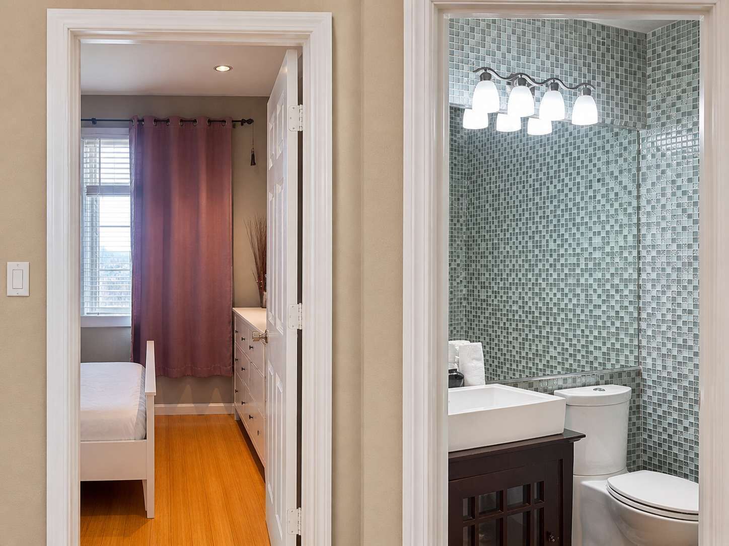 Un baño con salpicadero de azulejos, inodoro y lavamanos.