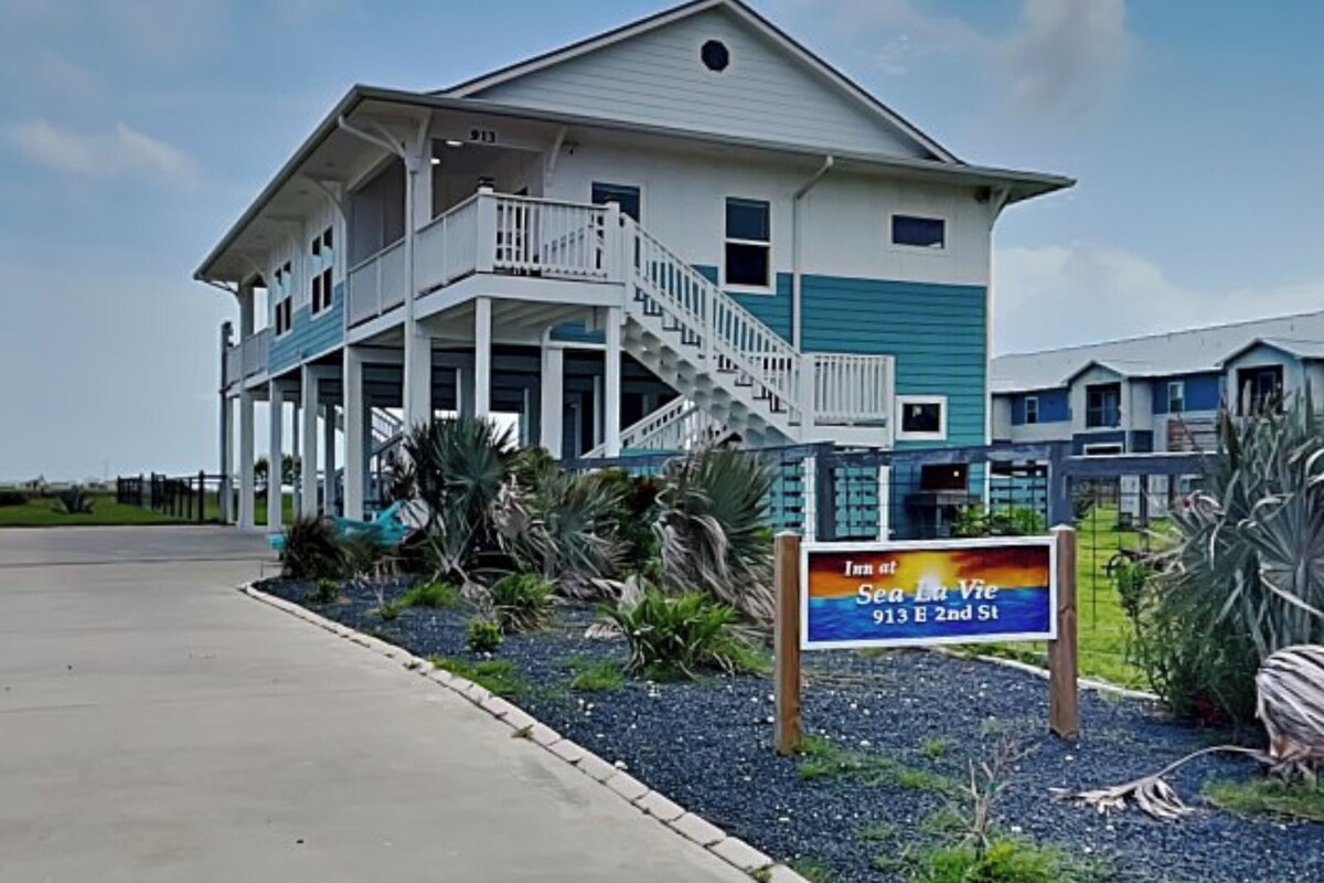 A two-story building with a balcony and a sign indicating it's the Sea Lu Vie Inn at 913 E 2nd St.