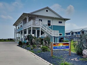 A two-story building with a balcony and a sign indicating the location of Sea Lu Vie.