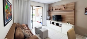 Ein modernes Wohnzimmer mit einer Couch, einem Fernseher und einem Essbereich.