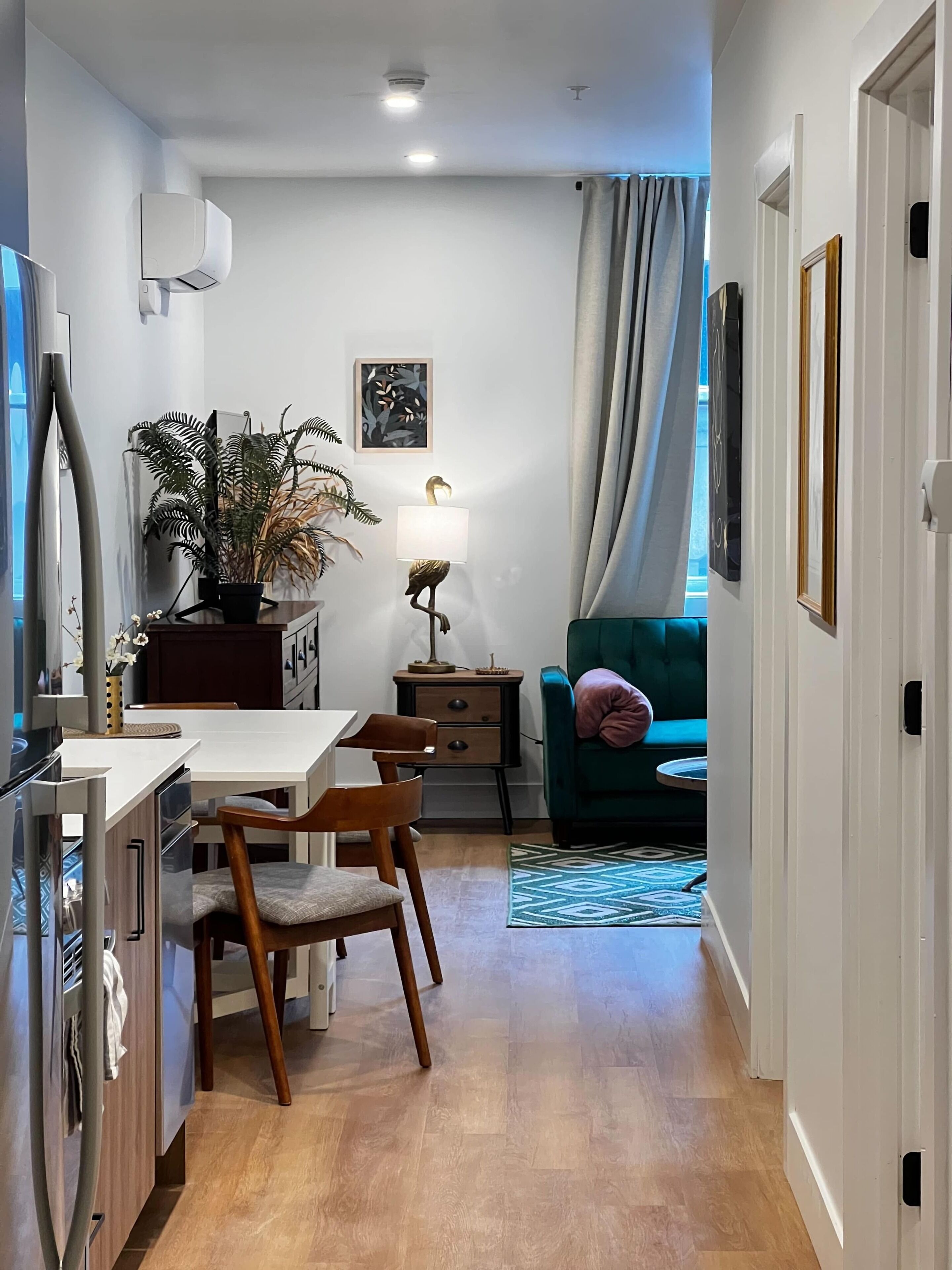 Une cuisine moderne avec un coin repas, un canapé de couleur turquoise et une plante en pot.