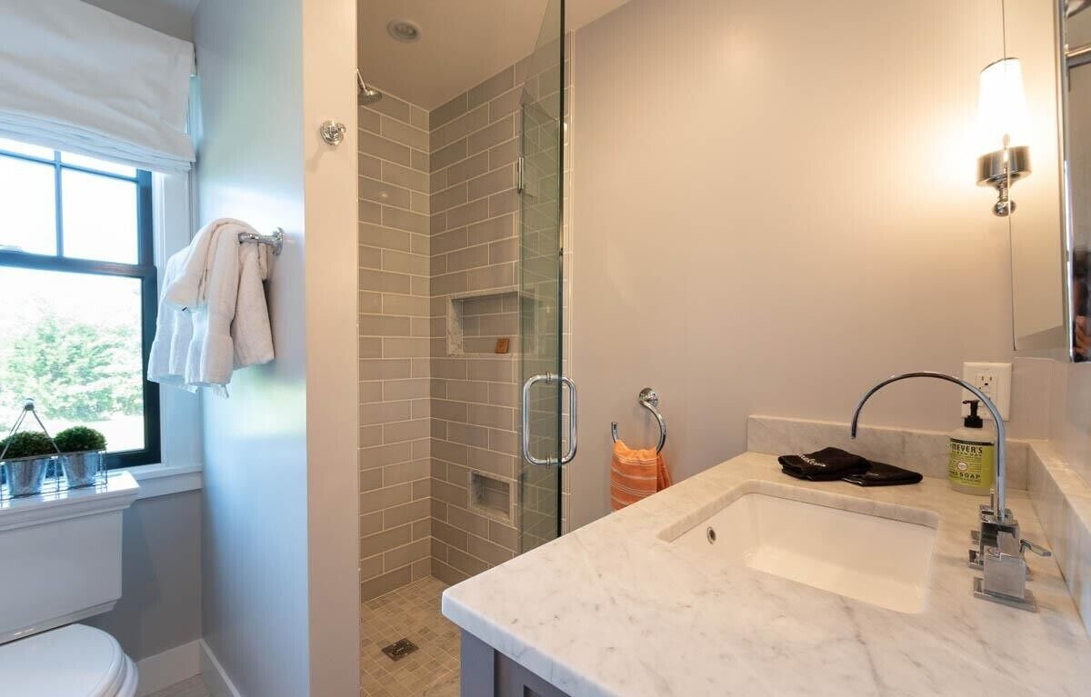 A bathroom with a shower, a sink, and a toilet.