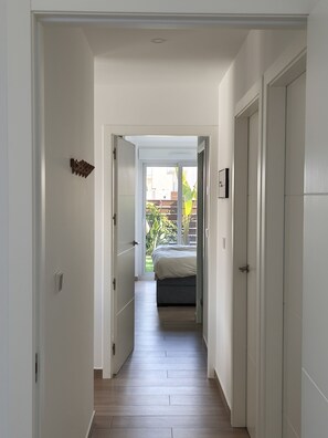 A narrow hallway leading to a bedroom with a bed, a door on the right, and a door on the left. - Casa Juanita with pool (Torremendo)