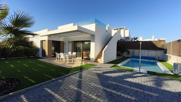 Une maison moderne dotée d’une piscine, d’une terrasse et d’un espace extérieur aménagé et abrité.