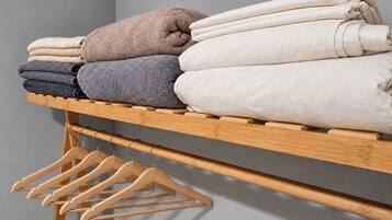 A wooden shelf with folded towels in various colors.