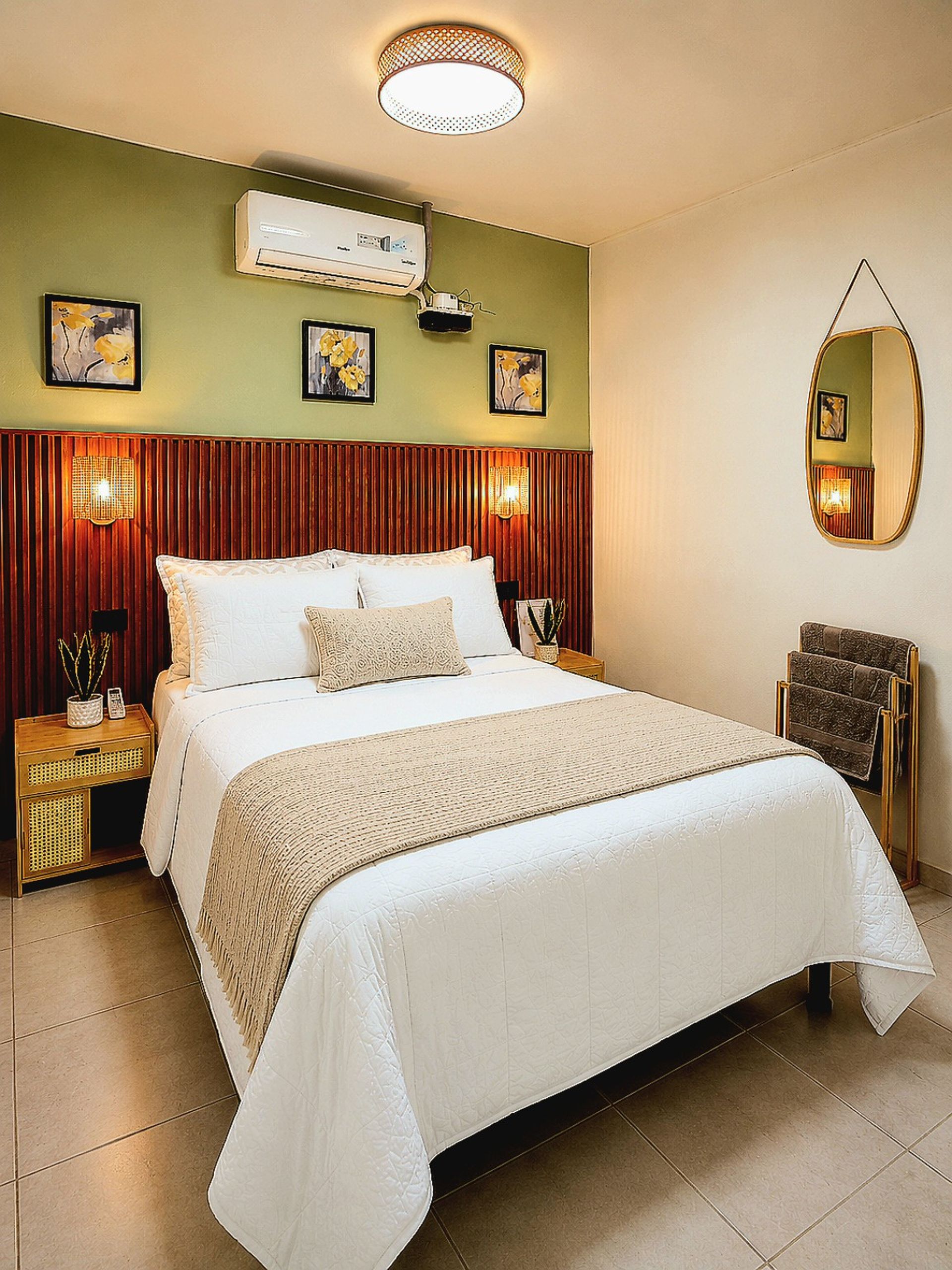 A hotel room with a large bed, a wall-mounted air conditioner, and a mirror.