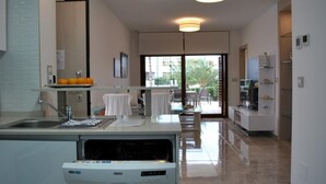 A modern kitchen with a dishwasher, a dining area with a table and chairs, and a view of the outside. - Ground floor Secreto La Zenia (La Zenia)