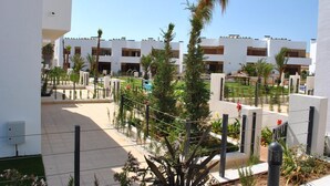 A modern building with multiple balconies, a well-maintained garden, and a clear sky. - Ground floor Secreto La Zenia (La Zenia)