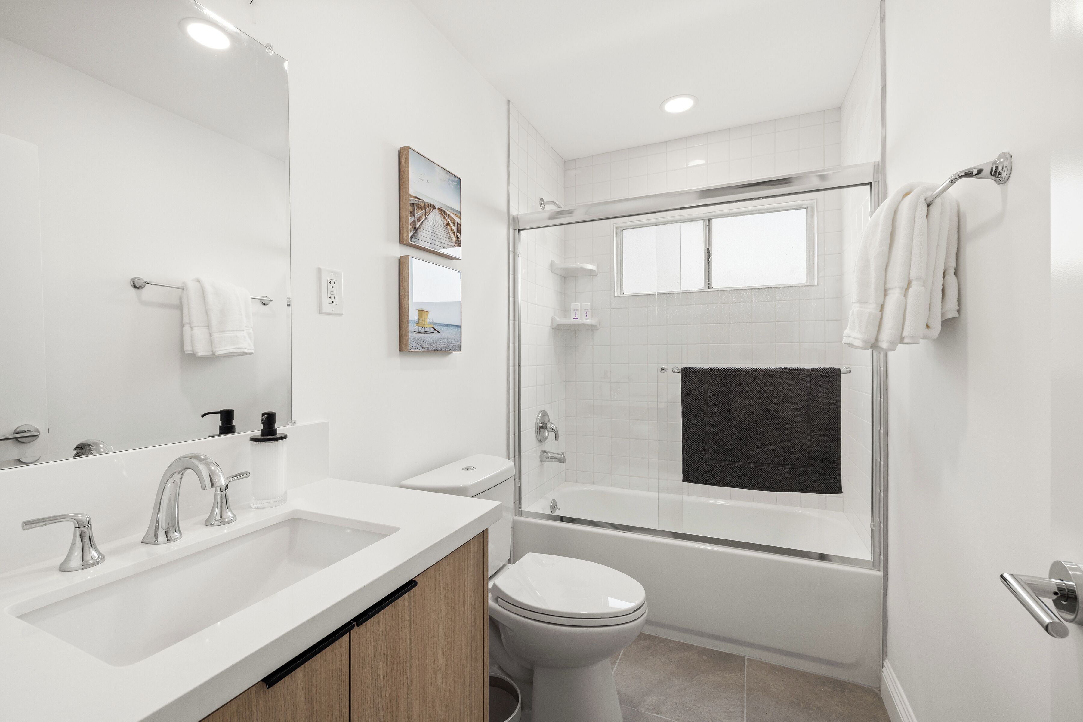 A modern bathroom with a glass-enclosed shower, a white sink, and a toilet.