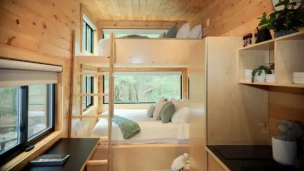 A compact room with a bunk bed, a desk, a bookshelf, and a window with a view of trees. - “At 84 Ranch, a place to rest, reconnect, and remember what’s real.” (Pagosa Springs)