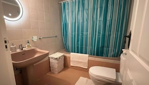 Ein Badezimmer mit Waschbecken, Toilette und Duschvorhang.