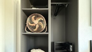 A grey wardrobe with shelves, a fan, a microwave, and a pair of shoes. - Stylish studio apartment near the Olma trade fair (St. Gallen)