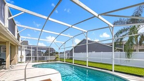 Piscina coberta com um banco, cercada por uma cerca branca e um céu claro.