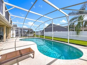 A covered swimming pool with a bench, surrounded by a white fence and a clear sky. - Serene Escape: Near Disney, South-Facing Pool & Game Room (Clermont)