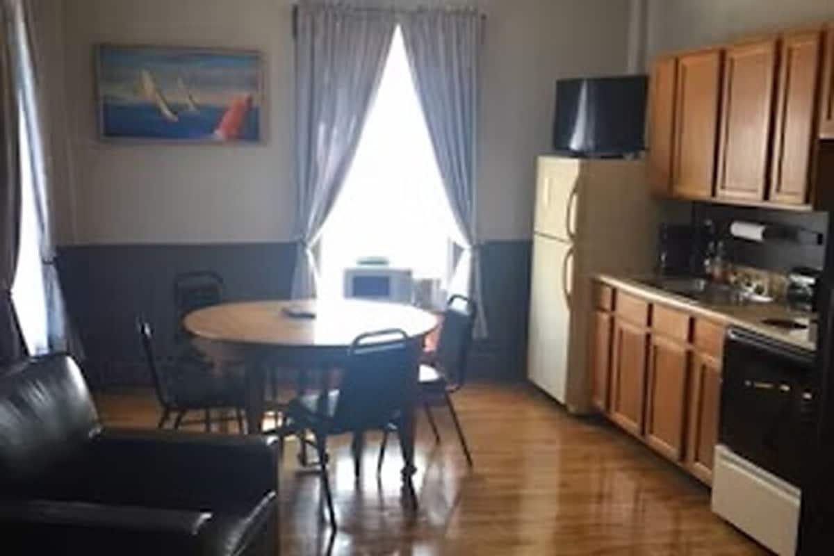 A compact kitchen with wooden cabinets, a refrigerator, and a microwave.