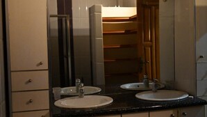 A bathroom with two sinks, a mirror, and a wooden door. - la villa du parc (Niaga)