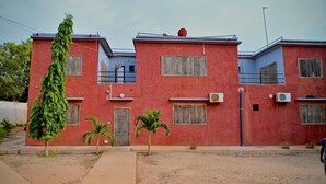 A red building with multiple windows and a flat roof. - la villa du parc (Niaga)